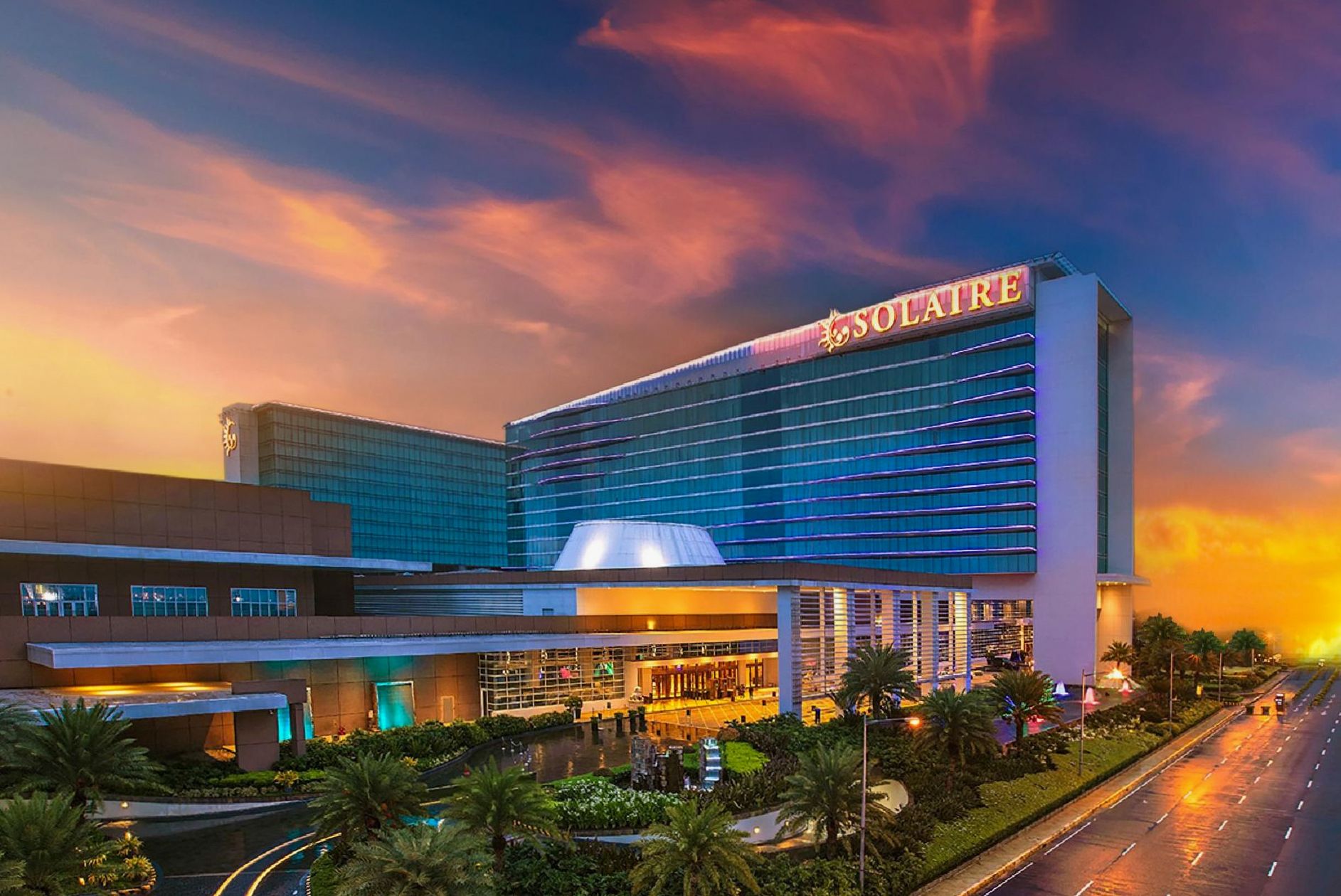 Solaire Resort Entertainment City illuminated at night over Manila Bay